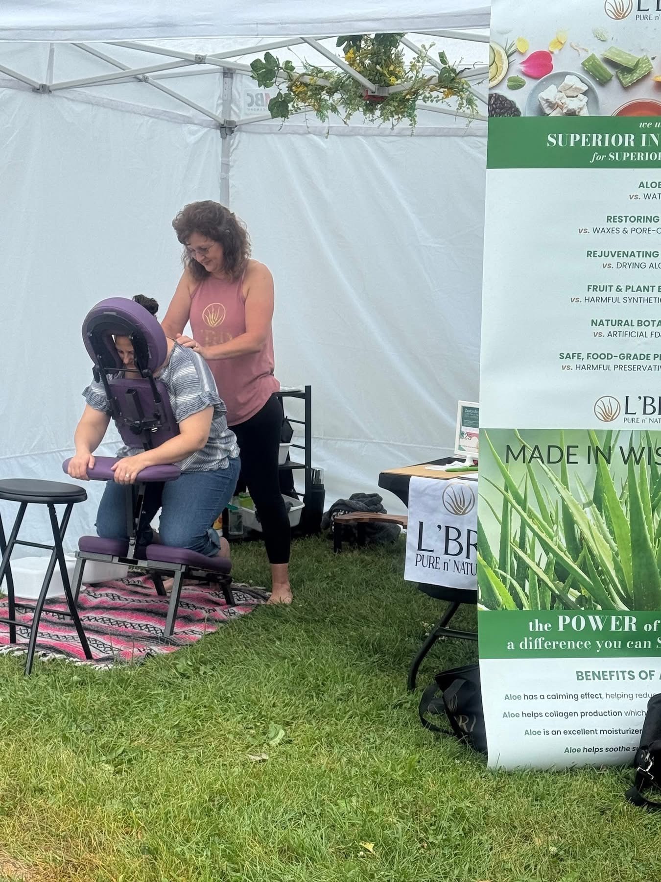 Leah Zastoupil providing chair massage for a client during Traveling Spa Experience.